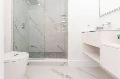 a white bathroom with a shower and a toilet at Yacht Club at Aventura Lux 2 Bed 2 Bath Brand New 2021 in Aventura
