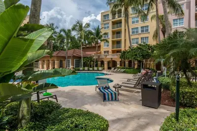 a pool at a resort with palm trees and a building at Yacht Club at Aventura Lux 2 Bed 2 Bath Brand New 2021 in Aventura
