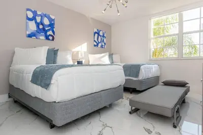 a white bedroom with two beds and a chair at Yacht Club at Aventura Lux 2 Bed 2 Bath Brand New 2021 in Aventura
