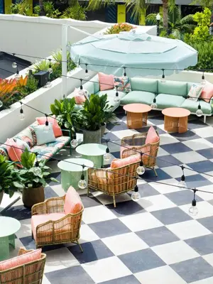 a patio with couches and tables on a checkered floor at The Goodtime Hotel, Miami Beach a Tribute Portfolio Hotel in Miami Beach