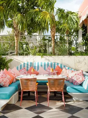 a table with two chairs and a couch with pillows at The Goodtime Hotel, Miami Beach a Tribute Portfolio Hotel in Miami Beach