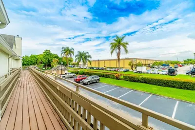 a balcony with a wooden boardwalk and a parking lot at Doral Inn & Suites Miami Airport West in Miami
