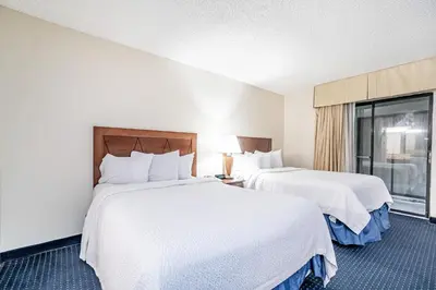 a hotel room with two beds and a window at Doral Inn & Suites Miami Airport West in Miami