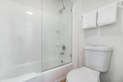 a white bathroom with a shower and a toilet at Doral Inn & Suites Miami Airport West in Miami