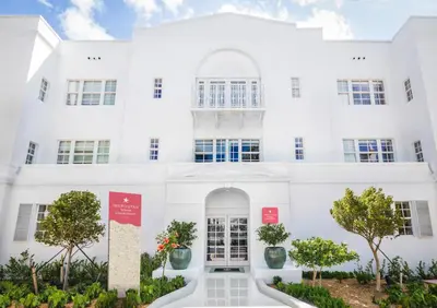 a white building with trees in front of it at Iberostar Waves Miami Beach in Miami Beach