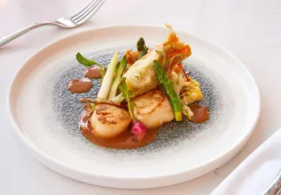 a white plate of food on a table at SERENA Hotel Aventura Miami, Tapestry Collection by Hilton in Aventura