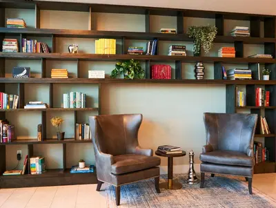 two chairs in front of a book shelf with books at SERENA Hotel Aventura Miami, Tapestry Collection by Hilton in Aventura