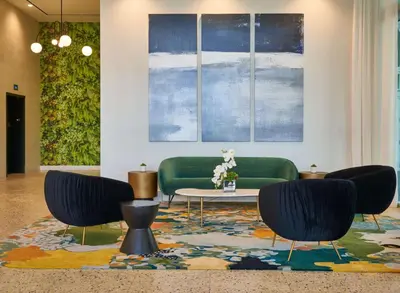 a living room with two green chairs and a table at SERENA Hotel Aventura Miami, Tapestry Collection by Hilton in Aventura