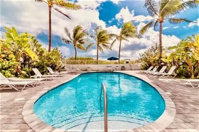 a swimming pool in a resort with palm trees at OCEAN FRONT BEACH PADS---South Beach in Miami Beach