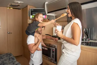 a man holding a little girl on his shoulders in a kitchen at Airstream in the Center of it All in Miami