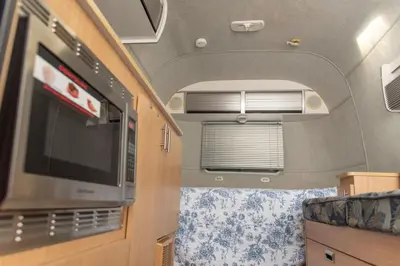 an interior of an rv with a window and a tv at Airstream in the Center of it All in Miami