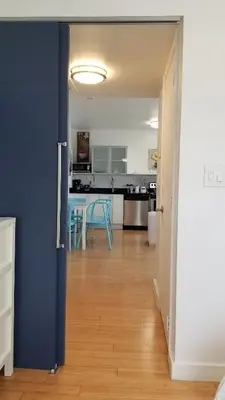 a kitchen and dining room with a blue wall at SOBE SUNSHINE ONE BEDROOM APARTMENTs in Miami Beach