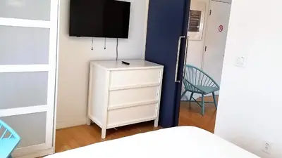a bedroom with a white dresser and a television on a wall at SOBE SUNSHINE ONE BEDROOM APARTMENTs in Miami Beach
