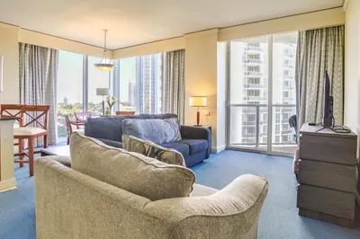 a living room with a couch and a tv at Pool and Tennis Beachfront Florida Condo! in Miami Beach