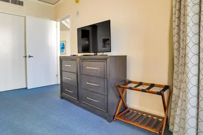 a room with a dresser with a television on top of it at Pool and Tennis Beachfront Florida Condo! in Miami Beach