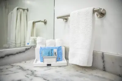 a bathroom with towels and a box on a counter at Modern and Luxurious Brickell Studio in Miami
