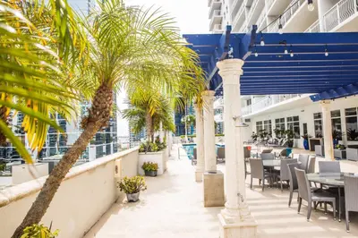 a balcony with tables and chairs and palm trees on a cruise ship at Modern and Luxurious Brickell Studio in Miami