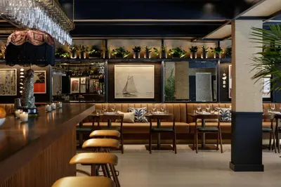 a restaurant with a bar with chairs and tables at The Kimpton Shorebreak Fort Lauderdale Beach Resort in Fort Lauderdale