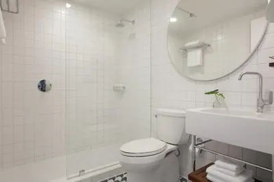 a bathroom with a toilet and a sink and a mirror at The Kimpton Shorebreak Fort Lauderdale Beach Resort in Fort Lauderdale