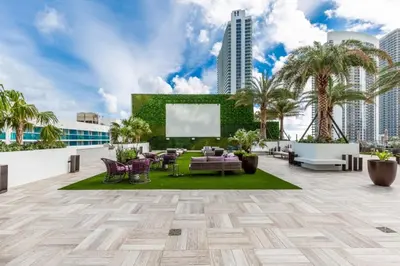 a rooftop patio with furniture and palm trees at Hyde Beach House Luxury Condo-Resort condo in Hollywood Beach