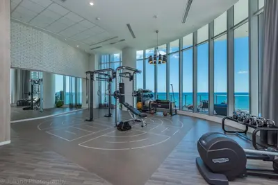 a gym with cardio equipment in a building with windows at Hyde Beach House Luxury Condo-Resort condo in Hollywood Beach