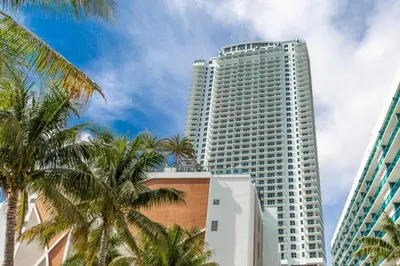 a tall white building with palm trees in front of it at Hyde Beach House Luxury Condo-Resort condo in Hollywood Beach