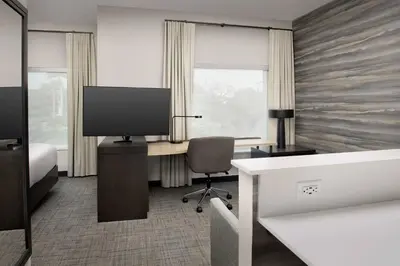 a bedroom with a desk with a television and a chair at Residence Inn Doral Mall Area in Doral