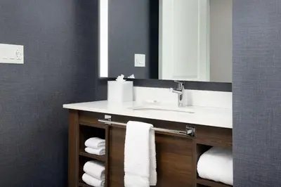 a bathroom with a sink and a mirror and towels at Residence Inn Doral Mall Area in Doral