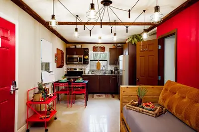 a living room with a kitchen and a red door at The Rum Locker - 1 King - 2 Twins - Private home and Patio - Sleeps 4 in Fort Lauderdale
