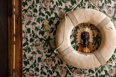 a mirror is hanging on a wall with flowers at The Rum Locker - 1 King - 2 Twins - Private home and Patio - Sleeps 4 in Fort Lauderdale