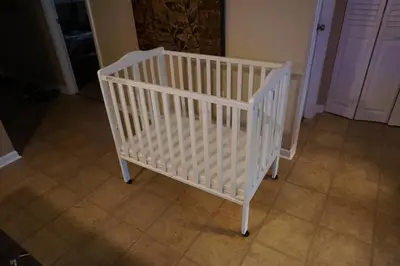 a white crib in a room with a tile floor at Walk to the Beach at Sunny Isles in Miami Beach