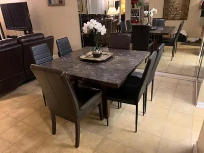a dining room table with black chairs and a vase of flowers at Walk to the Beach at Sunny Isles in Miami Beach