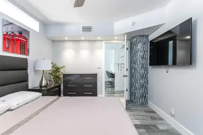 a bedroom with a large bed and a tv at AMAZING 2BR 2BA NEWLY RENO BEACHFRONT APT W/BEACH VIEW in Hollywood