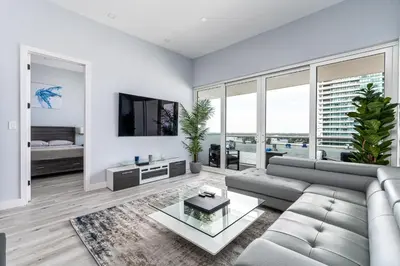 a living room with a couch and a tv at AMAZING 2BR 2BA NEWLY RENO BEACHFRONT APT W/BEACH VIEW in Hollywood