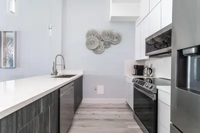 a white kitchen with a sink and a stove at AMAZING 2BR 2BA NEWLY RENO BEACHFRONT APT W/BEACH VIEW in Hollywood