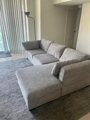 a gray couch in a living room with a rug at Spacious 1BR on the Beach, The Tides, Hollywood,FL in Hollywood