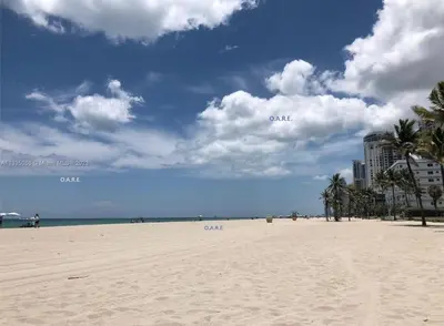 a sandy beach with buildings and palm trees on it at Spacious 1BR on the Beach, The Tides, Hollywood,FL in Hollywood