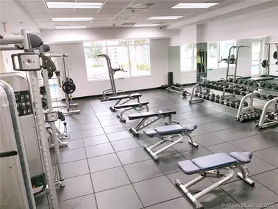 a gym with several rows of treadmills and machines at Downtown Miami Brickell Bay & Pool View 4 Bedrooms in Miami