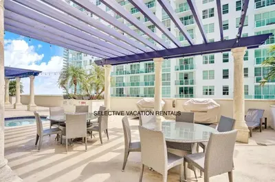 a patio with a table and chairs and a building at Downtown Miami Brickell Bay & Pool View 4 Bedrooms in Miami