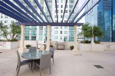 a patio with a glass table and chairs at Downtown Miami Brickell Bay & Pool View 4 Bedrooms in Miami