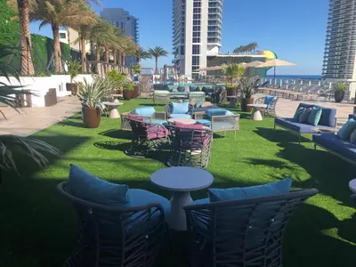a patio with chairs and tables on the grass at HYDE HOUSE 1906 HALLENDER MIAMI in Hollywood