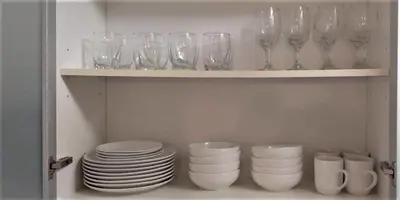 a cupboard filled with glasses and plates and bowls at *530 BEACH PAD-OCEAN DRIVE* in Miami Beach