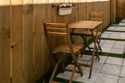 a wooden table and chairs with a potted plant on a fence at Casa Madeira 2@ the heart of Miami Design District in Miami