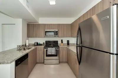 a kitchen with a stainless steel refrigerator and cabinets at Roami at Grove 27 in Miami