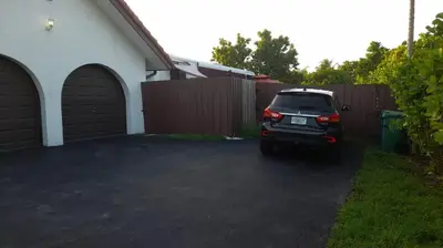 a car parked in a driveway next to a fence at Spanish Style House - Free Parking in Miami