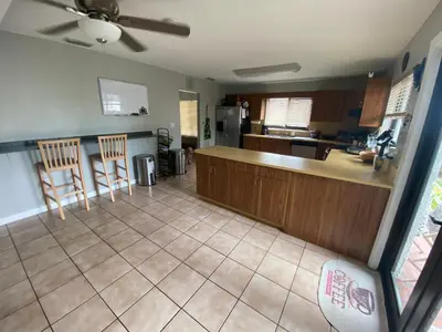 a kitchen with a counter and chairs in a room at Spanish Style House - Free Parking in Miami