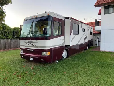an rv parked in a yard next to a house at Remodeled and Comfortable RV - FREE PARKING in Miami