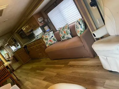 an rv living room with a couch and a window at Remodeled and Comfortable RV - FREE PARKING in Miami