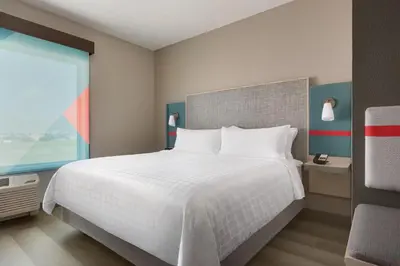 a bedroom with a large white bed and a window at avid hotel - Ft Lauderdale Airport - Cruise by IHG in Fort Lauderdale