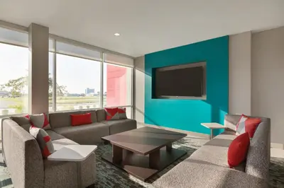 a living room with a couch and a tv on a wall at avid hotel - Ft Lauderdale Airport - Cruise by IHG in Fort Lauderdale